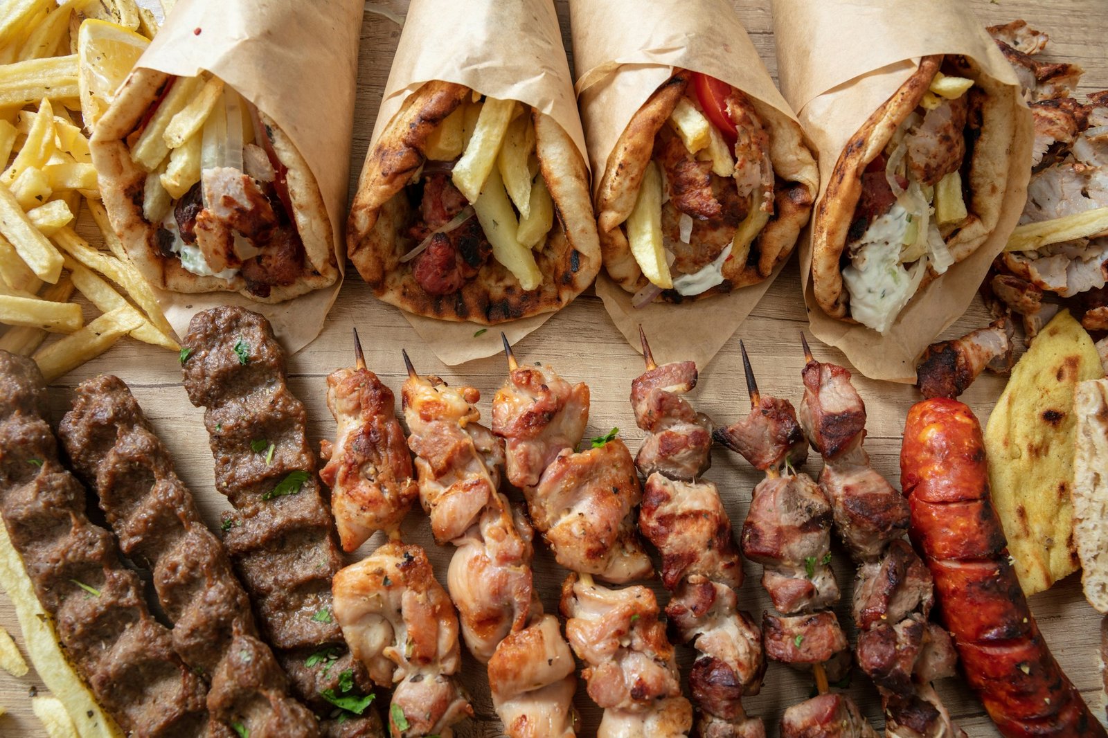 Greek street food, gyro sliced meat pita bread wrap, chiken and pork souvlaki skewer, overhead